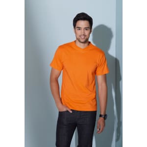 An orange V-T Medium T-shirt worn by a smiling man, standing against a pale blue wall.