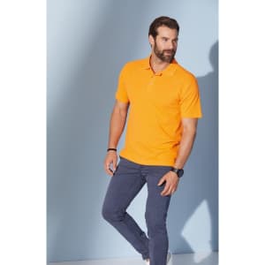 An orange polo shirt displayed on a man, paired with navy blue trousers against a light background.