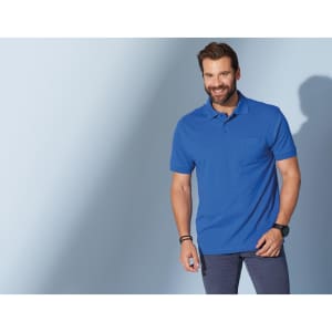 A blue polo shirt with a pocket, modelled by a smiling man, against a soft blue background.