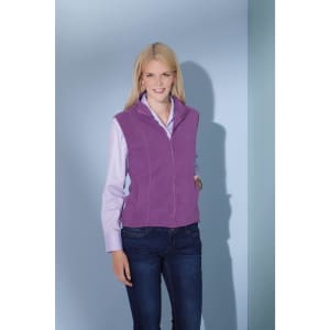 A purple microfleece vest worn over a light pink shirt, paired with dark jeans. The model has long blonde hair.