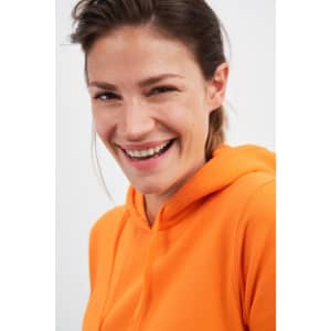 An orange hooded sweatshirt worn by a smiling woman, featuring a hood and a comfortable fit.