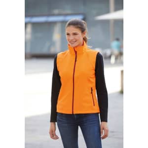 A bright orange ladies softshell vest with a zip front and a fitted design, featuring a logo.