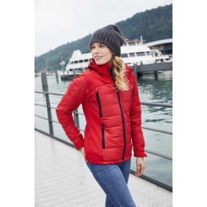 A red ladies' outdoor hybrid jacket with a hood, worn by a woman by the water, featuring a knit beanie.
