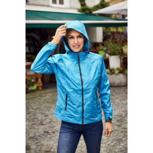 A blue ladies rain jacket with a hood, featuring zippered pockets and worn by a woman outdoors.