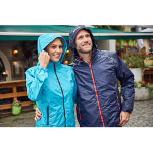 A light blue ladies rain jacket and a navy men's rain jacket, both featuring hoods, in an outdoor setting.