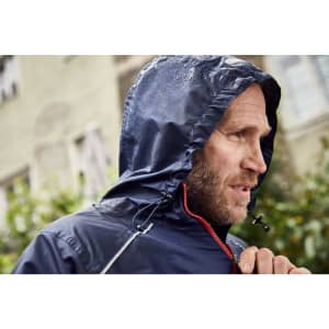 A man's navy rain jacket with a hood, featuring a zippered front and drawstring, worn in a rainy outdoor setting.