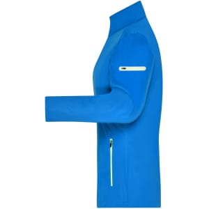 A blue ladies softshell jacket featuring a zippered pocket and a sleek design. It includes a logo on the sleeve.