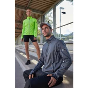A grey men's softshell jacket with a logo, paired with a model in a bright green jacket, both in an outdoor setting.