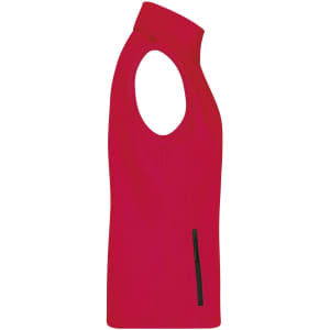 A red ladies softshell vest featuring a sleeveless design and a side zip pocket. It has a logo on it.