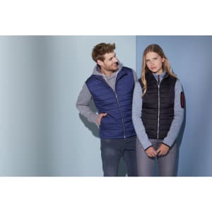 A navy and black padded vest displayed by a male and female model against a blue background.