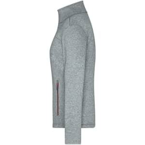 A ladies softshell jacket in grey with a high collar and a zippered pocket on the side. It features a branded logo.