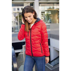 A red padded jacket with a hood, featuring a sleek design and contrast detailing, worn by a smiling woman outdoors.
