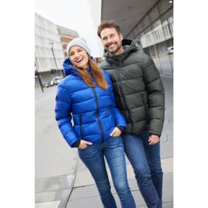 A blue padded jacket worn by a woman and a green padded jacket worn by a man, both smiling outdoors.