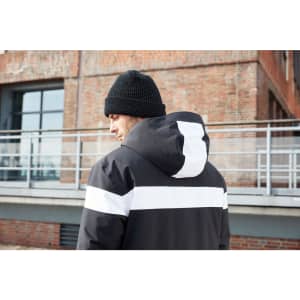 A men's winter sport jacket in black with white stripes, featuring a hood, worn by a person from the back.