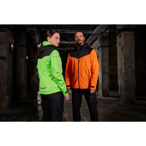 A green and black ladies rain jacket and an orange and black men's rain jacket are displayed together in an industrial setting.