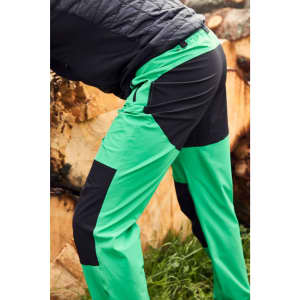Men's trekking pants in vibrant green and black, featuring cargo pockets and a sporty design. Includes branding.