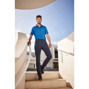 Cargo pants in navy blue worn by a man standing on a staircase, paired with a blue polo shirt.