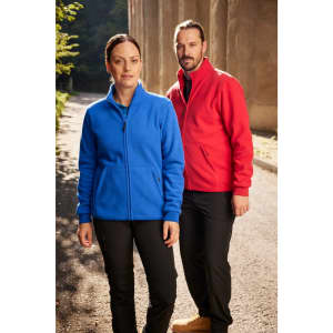 A blue fleece jacket on a woman and a red fleece jacket on a man, both standing outdoors.