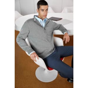 A grey zip cardigan worn by a man seated in a chair, accompanied by a blue shirt and navy trousers.