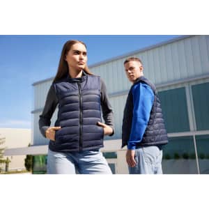 A navy padded vest is displayed on two people outdoors, one wearing a grey top and the other in a blue top.