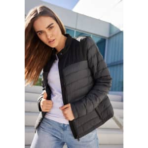 A black padded jacket with a zip, featuring a sleek design and a logo, worn by a model outdoors.