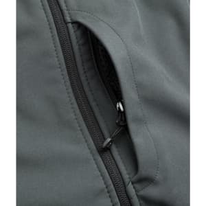 A close-up of a grey softshell jacket featuring a zippered pocket detail. The fabric appears smooth and durable.
