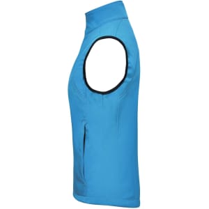 A blue ladies softshell vest with a high collar and no sleeves, featuring a side pocket and a logo.