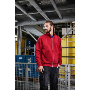 A red doubleface jacket is displayed on a model in a work environment, showcasing its practical design.