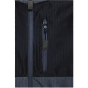 A close-up of a black Hardshell Workwear Jacket featuring multiple zippered pockets and textured fabric.