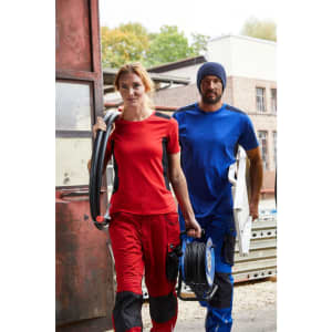 A red work T-shirt and blue work T-shirt being worn by a man and woman, both in casual work attire.