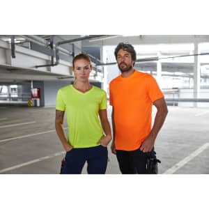 Two individuals stand together in a parking garage, wearing a neon yellow and an orange T-shirt. The shirts have a logo.
