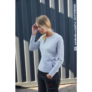 A grey long-sleeve t-shirt displayed on a model against a striped background, featuring a logo.