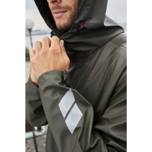 A model wearing an olive green rain jacket with a hood, featuring a logo on the sleeve.