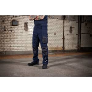 Winter workwear pants in navy blue, featuring cargo pockets and a fitted design, showcased against an industrial background.