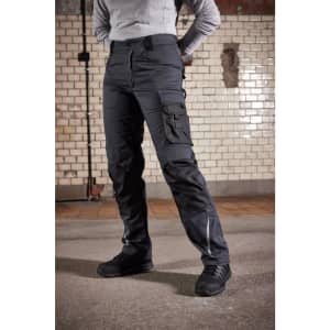 Winter workwear pants in black, featuring cargo pockets and a sturdy design. A person stands wearing them, paired with black shoes.