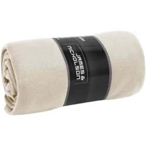 A rolled fleece blanket in a soft cream colour, featuring a branded label.