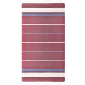 A striped beach blanket featuring shades of red and blue with tasselled edges, along with a brand logo.