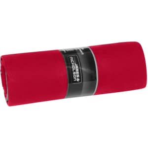 A rolled red picnic blanket with a black label. The blanket is smooth and neatly folded for storage.
