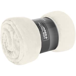 A rolled microfibre fleece blanket in a soft cream colour, featuring a branding label.