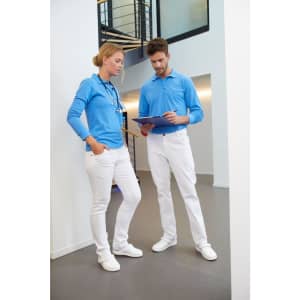 A woman in blue and a man in blue shirts wearing white stretch pants stand together indoors, reviewing a tablet.