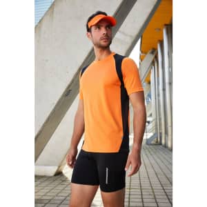A man in a fluorescent yellow and black running T-shirt, paired with black shorts and a visor, stands outdoors.