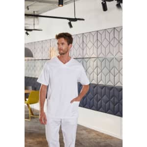 A man wearing a white men's stretch casack with short sleeves and pockets, standing in a modern space.