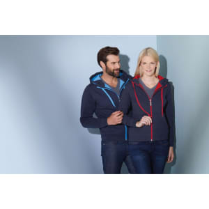 A couple models a navy doubleface jacket with blue and red accents, featuring a logo on the jacket.