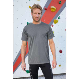 A grey men's active T-shirt displayed on a model in front of a colourful climbing wall. The shirt has a logo.