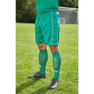 Green sports shorts with light green side stripes, worn with matching long socks, set against a grassy field.