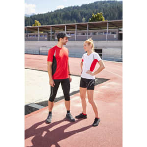 A red and white Ladies Running-T featured on a woman and a coordinated outfit on a man, both set on an athletic track.