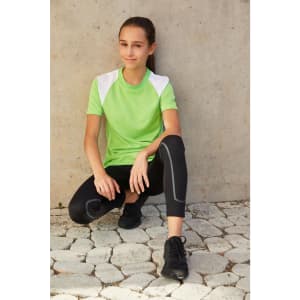 A green T-shirt with white shoulder panels, paired with black leggings and sneakers, displayed on a model.