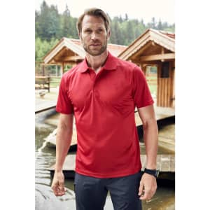 A red men's polo shirt is displayed on a man standing near wooden structures by water. The shirt features a logo.