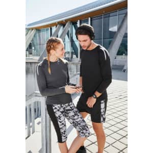 A pair of models wearing a grey long-sleeved ladies sports shirt and matching activewear. The shirt features colour detailing.