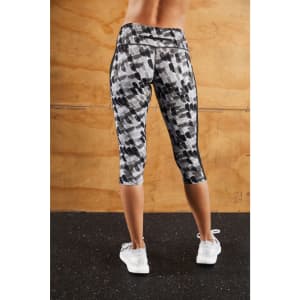 A pair of grey and black patterned 3/4 tights with a logo, suitable for women's activewear.